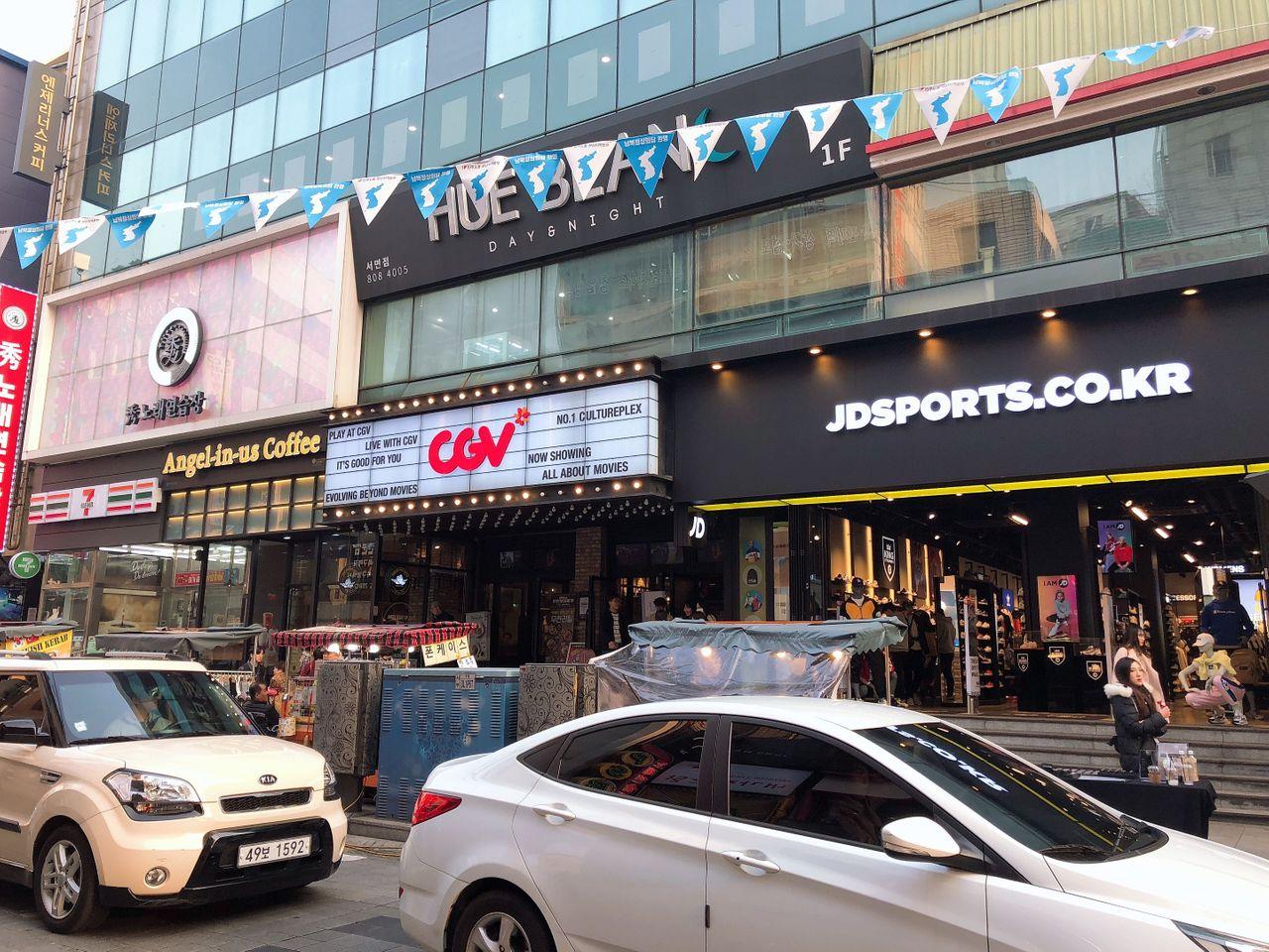 位于釜山西面购物商圈的CGV电影院正门，旁边有JD体育用品店。